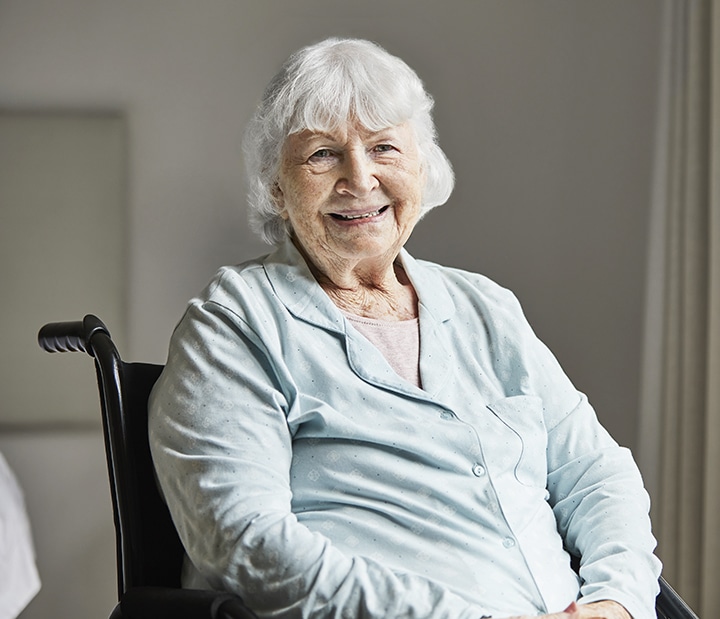 Smiling senior female sitting on wheelchair