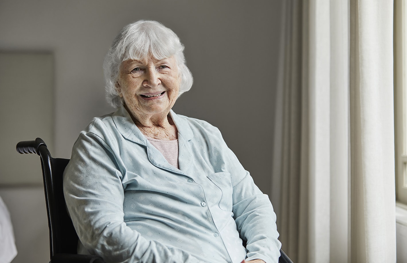 Smiling senior female sitting on wheelchair